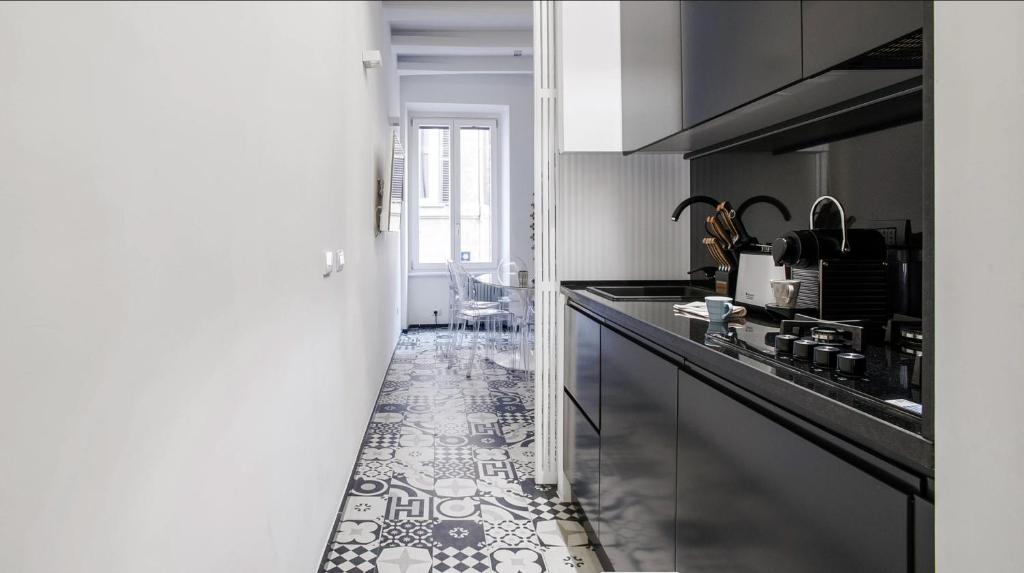 kuchnia z czarnym blatem i podłogą wyłożoną kafelkami w obiekcie Navona Hi-Tech Apartment w Rzymie