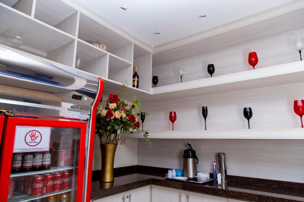 a red refrigerator in a kitchen with shelves at Revitalle Hotel in Votuporanga