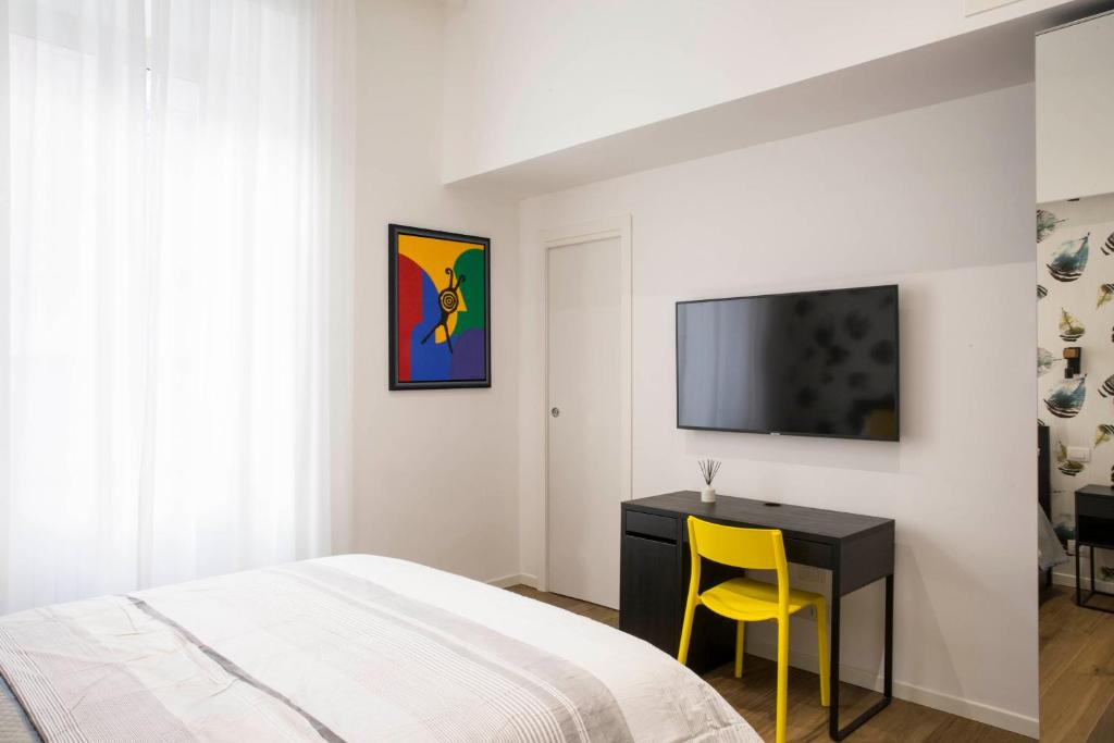 a bedroom with a bed, desk, and television at Four Elements in Rome