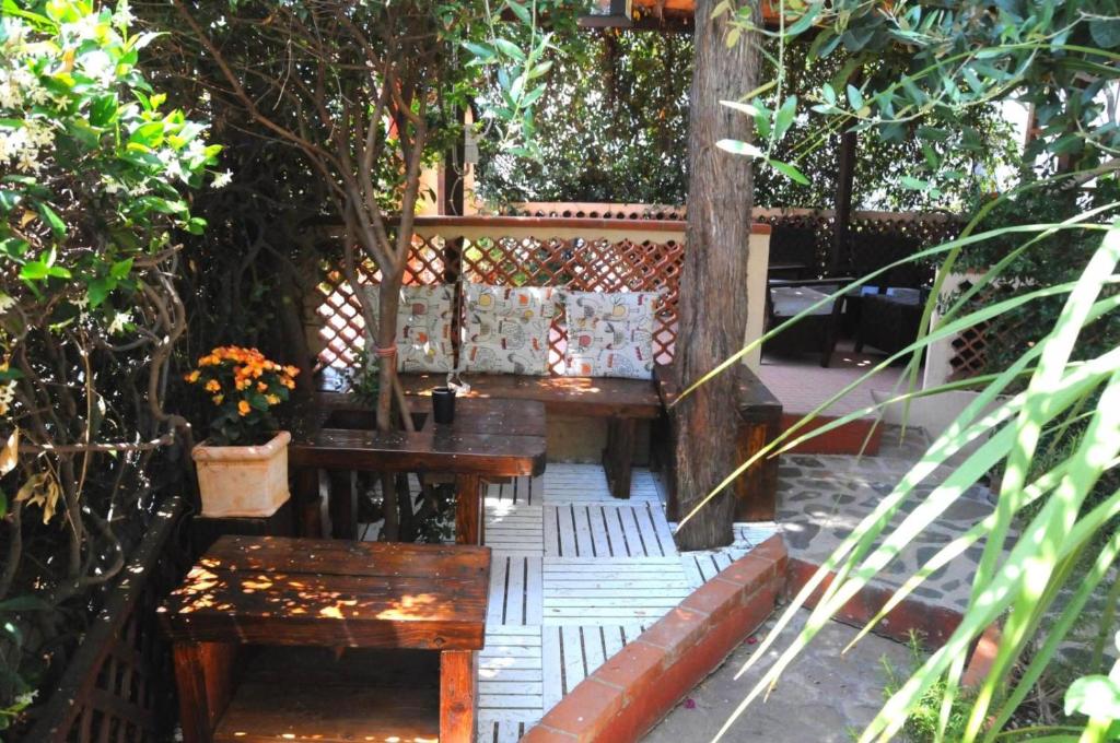 a group of benches sitting in a garden at B&B Casa Derosas in Golfo Aranci