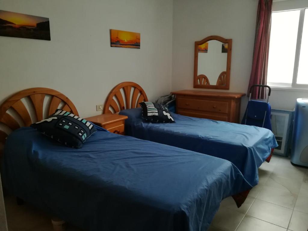 um quarto com 2 camas e um espelho em Large beachfront apartment Medano em El Médano