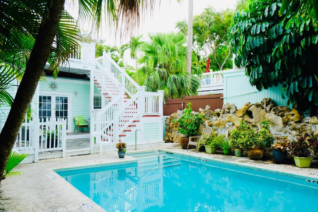 a house with a swimming pool and a white staircase at The Casablanca Hotel in Key West