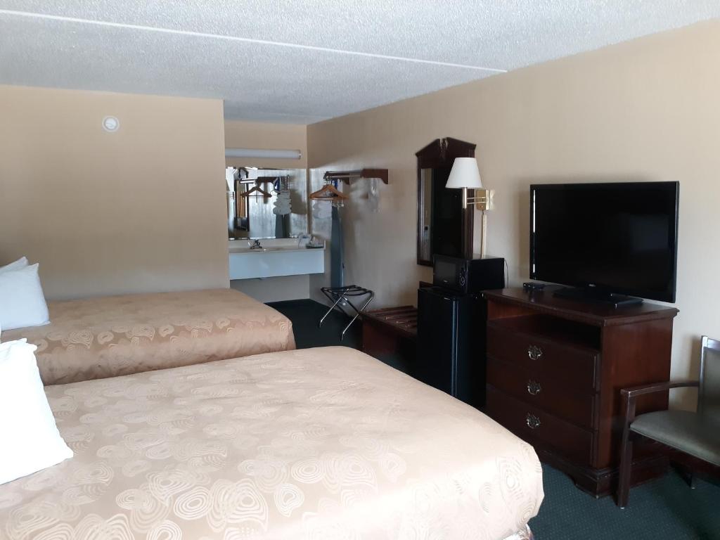 a hotel room with two beds and a flat screen tv at Angel Inn - near IMAX in Branson