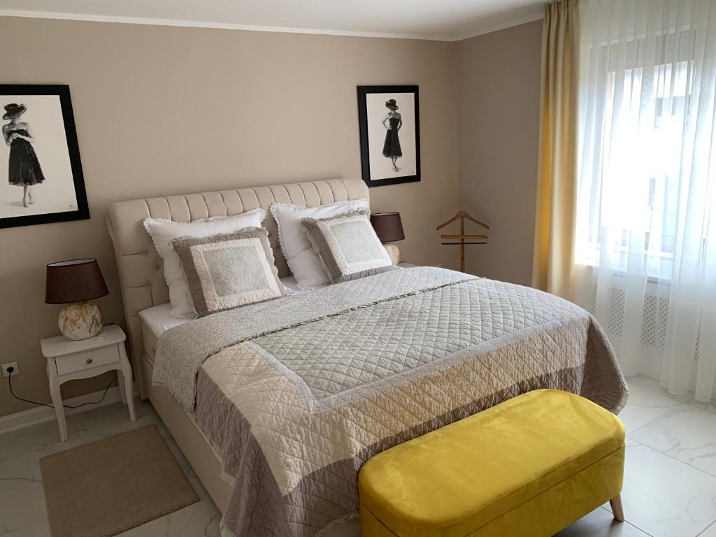 ein Schlafzimmer mit einem großen Bett und einem gelben Stuhl in der Unterkunft Ferienwohnungen am Klosterberg in Bad Neuenahr-Ahrweiler