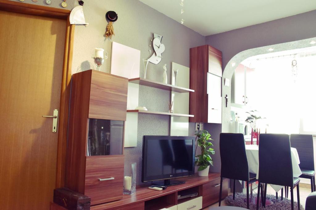 - un salon avec une télévision sur un centre de divertissement en bois dans l'établissement Apartment Živković, à Crikvenica