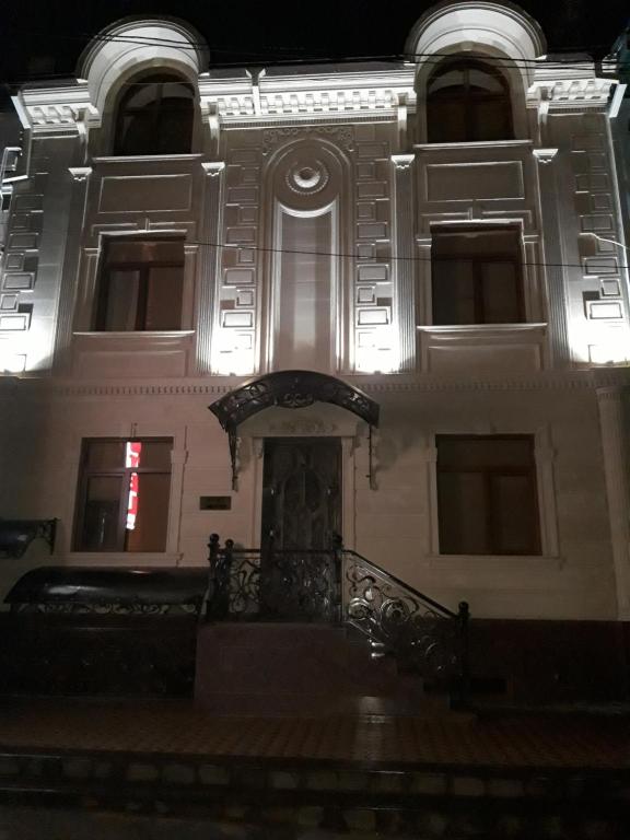 un bâtiment avec un escalier devant lui la nuit dans l'établissement Hotel Al-Bukhory, à Samarcande