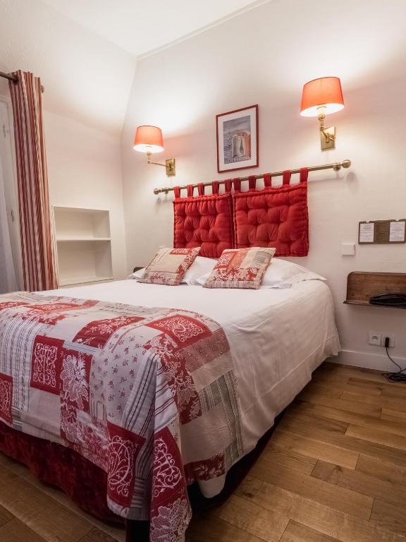 a bedroom with a large bed with a red headboard at New Orient Hotel in Paris