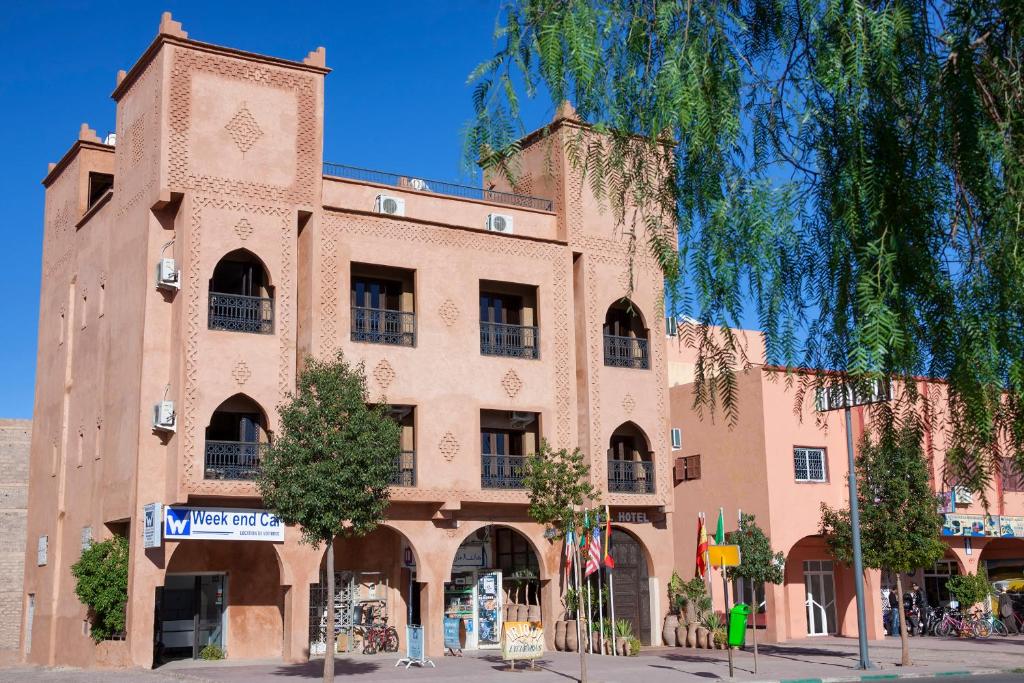 a large brick building on a city street at Hotel Azoul in Ouarzazate