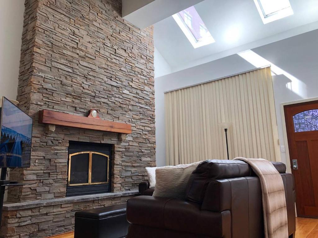 a living room with a couch and a brick fireplace at Full loft-style apartment near Omni in New Haven