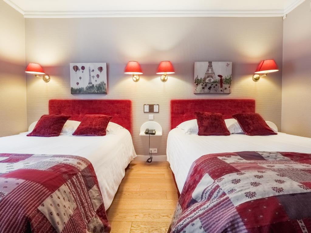 two beds in a room with red headboards at New Orient Hotel in Paris