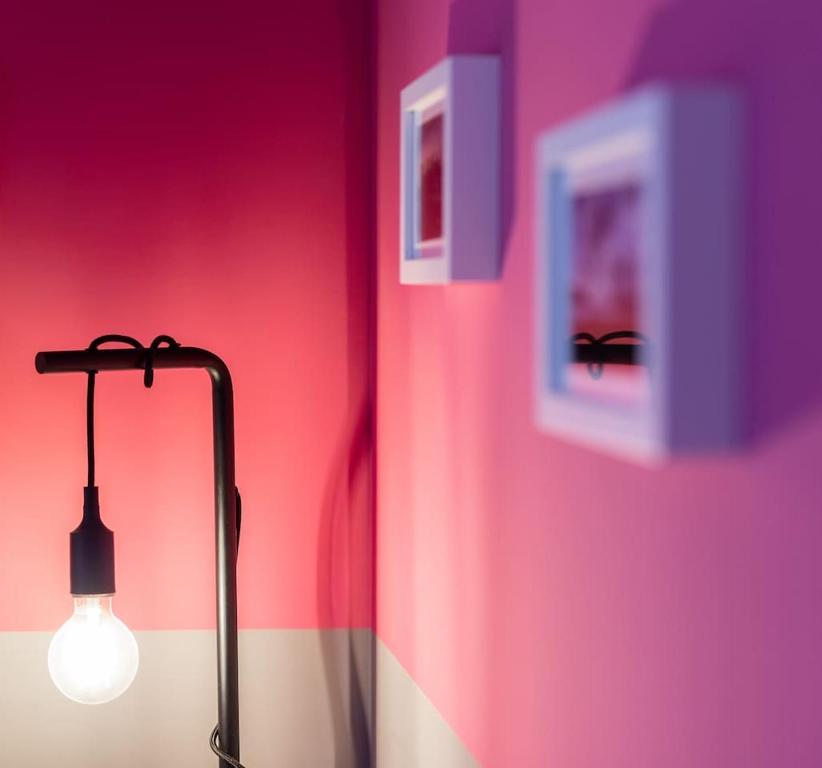 eine Lampe in einem Zimmer mit rosa und lila Wänden in der Unterkunft Il Sopracciglio Suites - Pink Apartment in Cassino