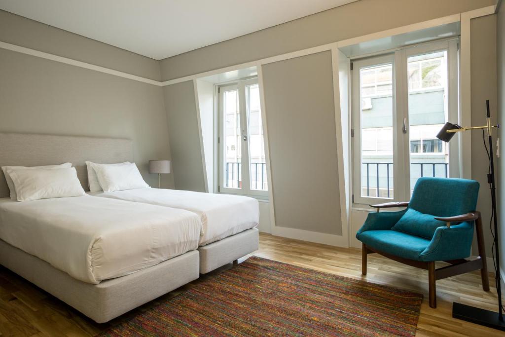 a bedroom with a bed and a blue chair at Porto Republica Apartments in Porto