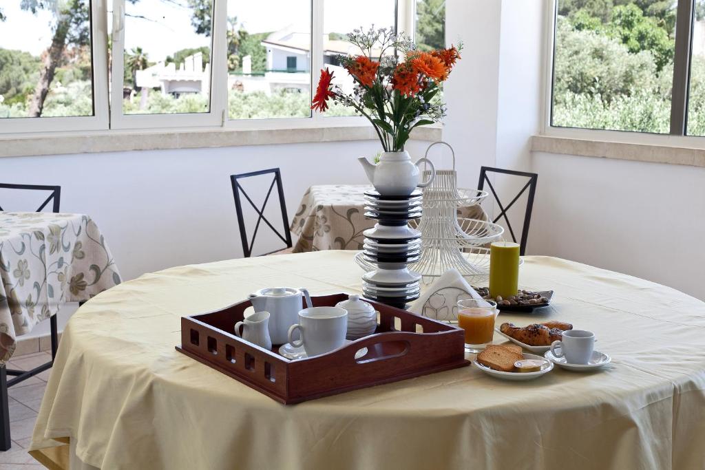 una mesa con una bandeja de comida para el desayuno. en Hotel La Campana, en Casarano