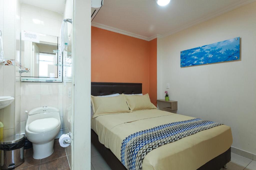 Habitación con baño con cama y aseo. en Apartamentos Laureles de la 70, en Medellín