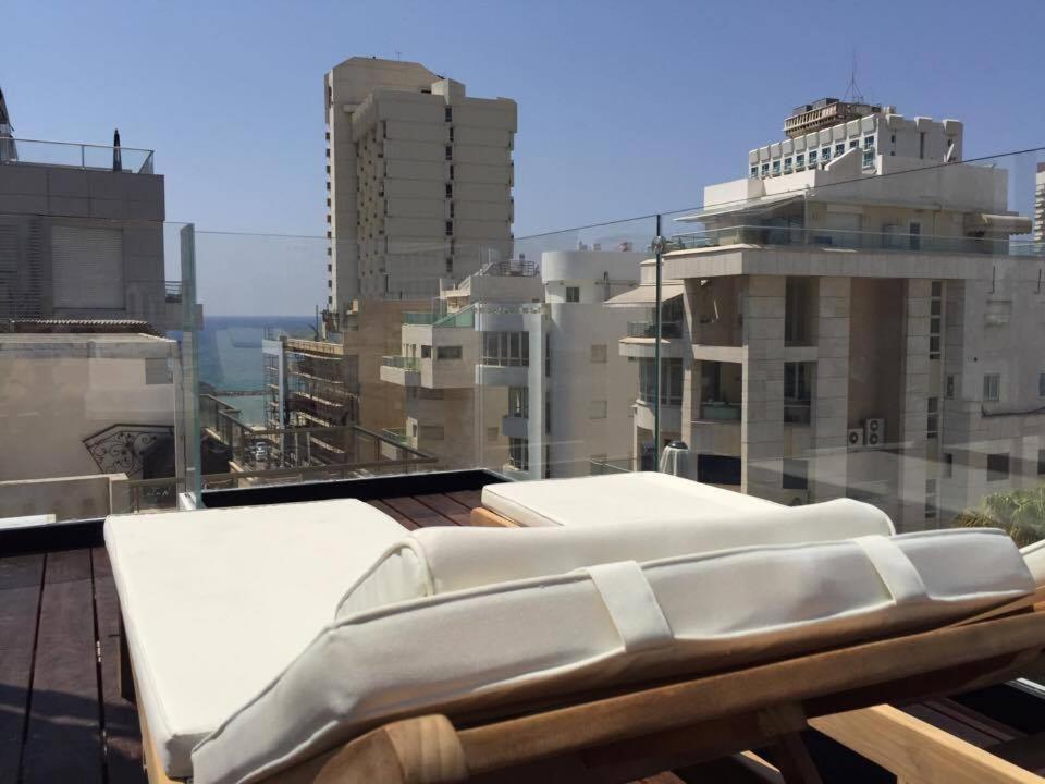 a couch on top of a roof with buildings at Luxury apartment Tel Aviv Gordon Beach Ha Yarkon in Tel Aviv