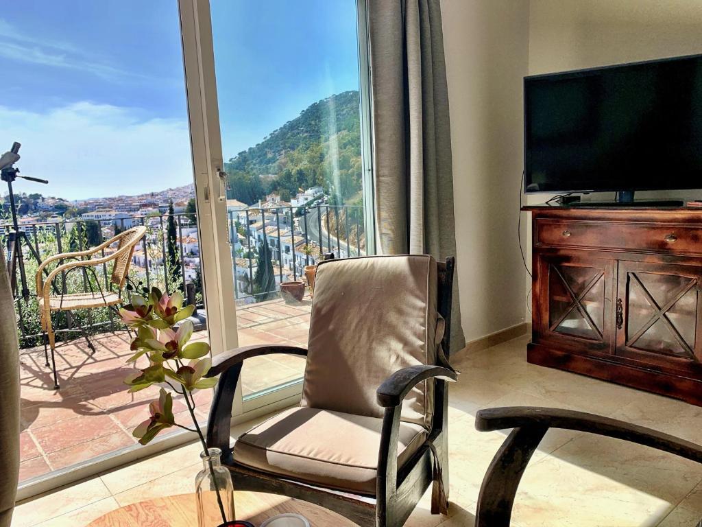 a living room with a chair and a large window at Villa Panorama Mijas Pueblo in Mijas