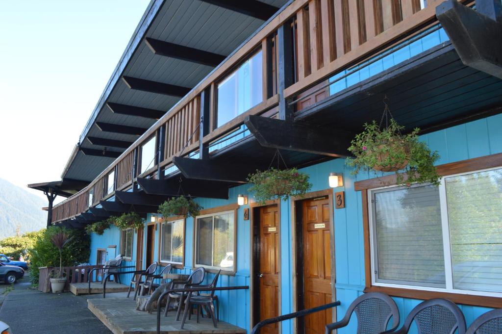 a building with chairs and tables in front of it at Meares Vista Inn in Tofino