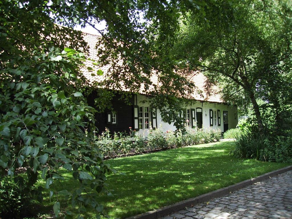 ein Haus mit grünem Rasen davor in der Unterkunft Hotel Landhuis &#39;t Wilgenerf in Ypern