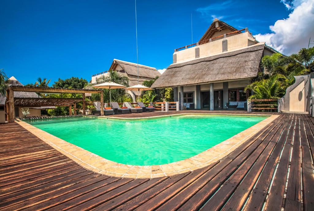 a swimming pool in front of a house at Vila Sol e Sal in Vilanculos