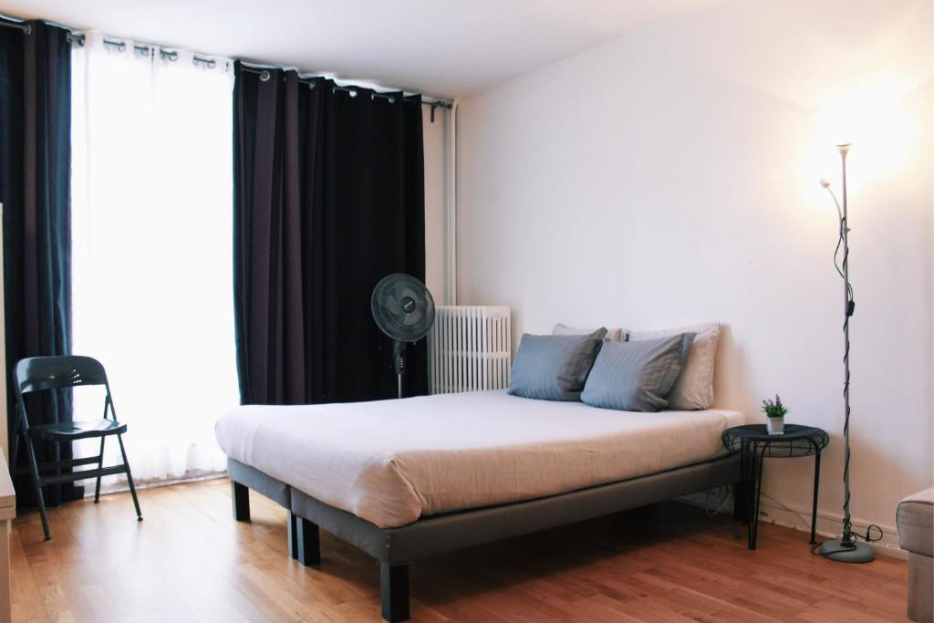 - une chambre avec un lit et un ventilateur dans l'établissement Lauriston Nice Studio, à Paris