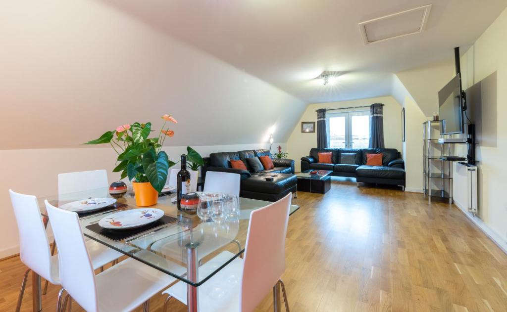 a dining room and living room with a table and chairs at Huge Luxury Penthouse Apartment with King Bed in St. Ives