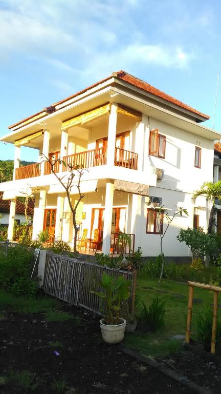 a large white house with windows and a fence at Gula Juruh Beach Front in Amed