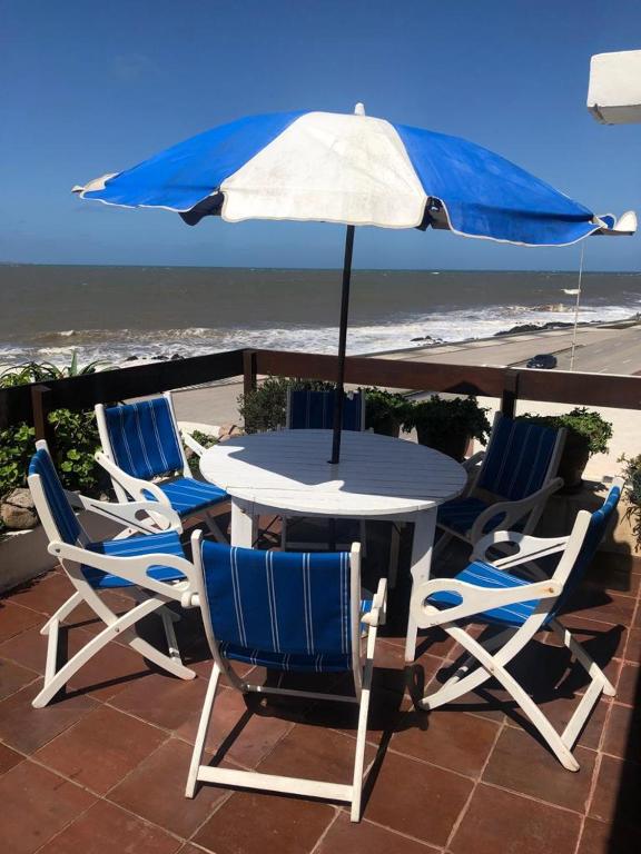 a table and chairs with an umbrella on a patio at Departamento Mar Punta del Este in Punta del Este
