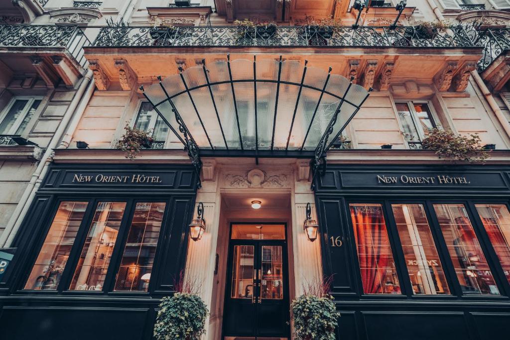 a building with the front of a newwich hotel at New Orient Hotel in Paris