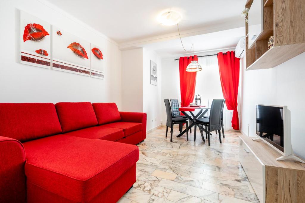 a living room with a red couch and a table at My Place @ Faro City Views in Faro