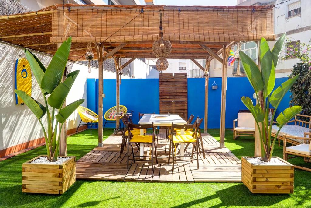 a patio with a table and chairs on grass at The Beach House Paradise by Hello Homes Sitges in Sitges