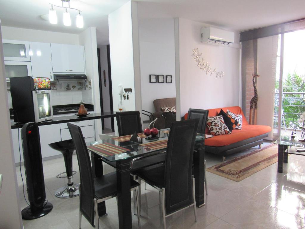 cocina y sala de estar con mesa y sillas en Reservas del peñon, en Girardot