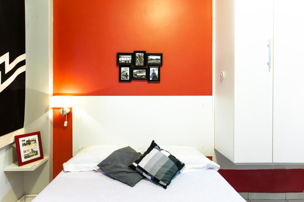 1 dormitorio con 1 cama con pared de color naranja en Flat a Beira Mar - Copacabana, en Río de Janeiro