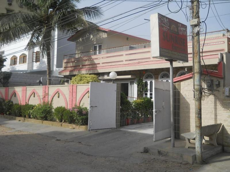 un edificio con dos puertas blancas en una calle en Sunrise Guest House Multan, en Multán