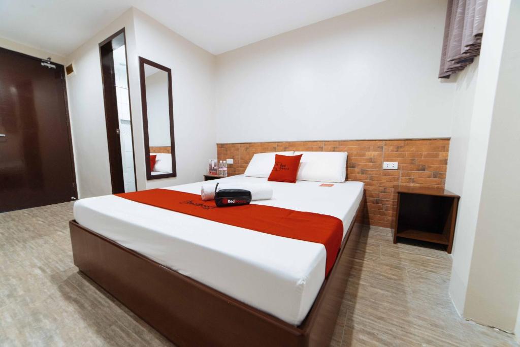 a bedroom with a large bed and a television at RedDoorz at Traveler's Inn Bajada Davao in Davao City