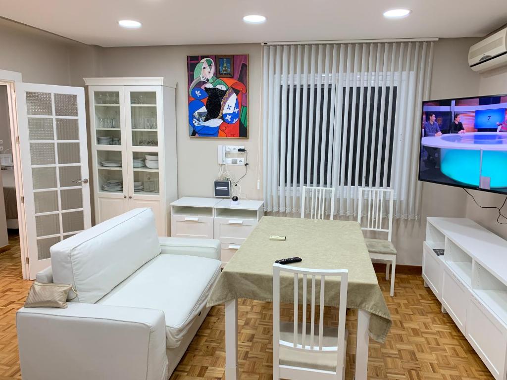 a living room with a couch and a table and a tv at Apartments soho, Malaga center in Málaga