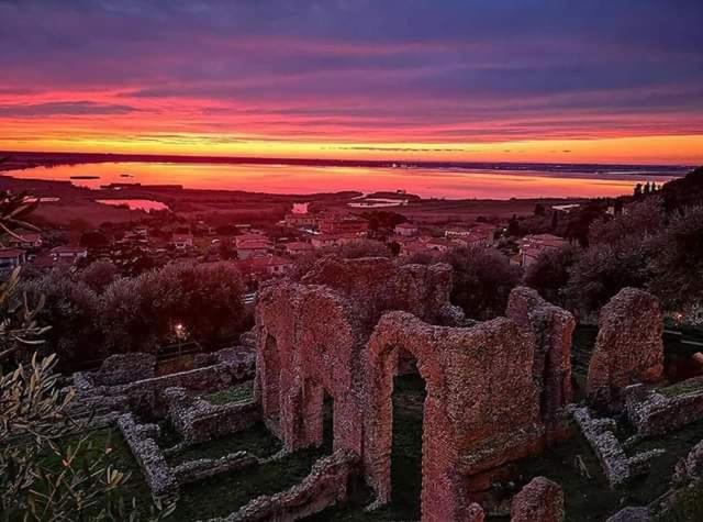 una puesta de sol sobre una ciudad con un montón de ruinas en CA' MENEGHETTI, en Massaciuccoli