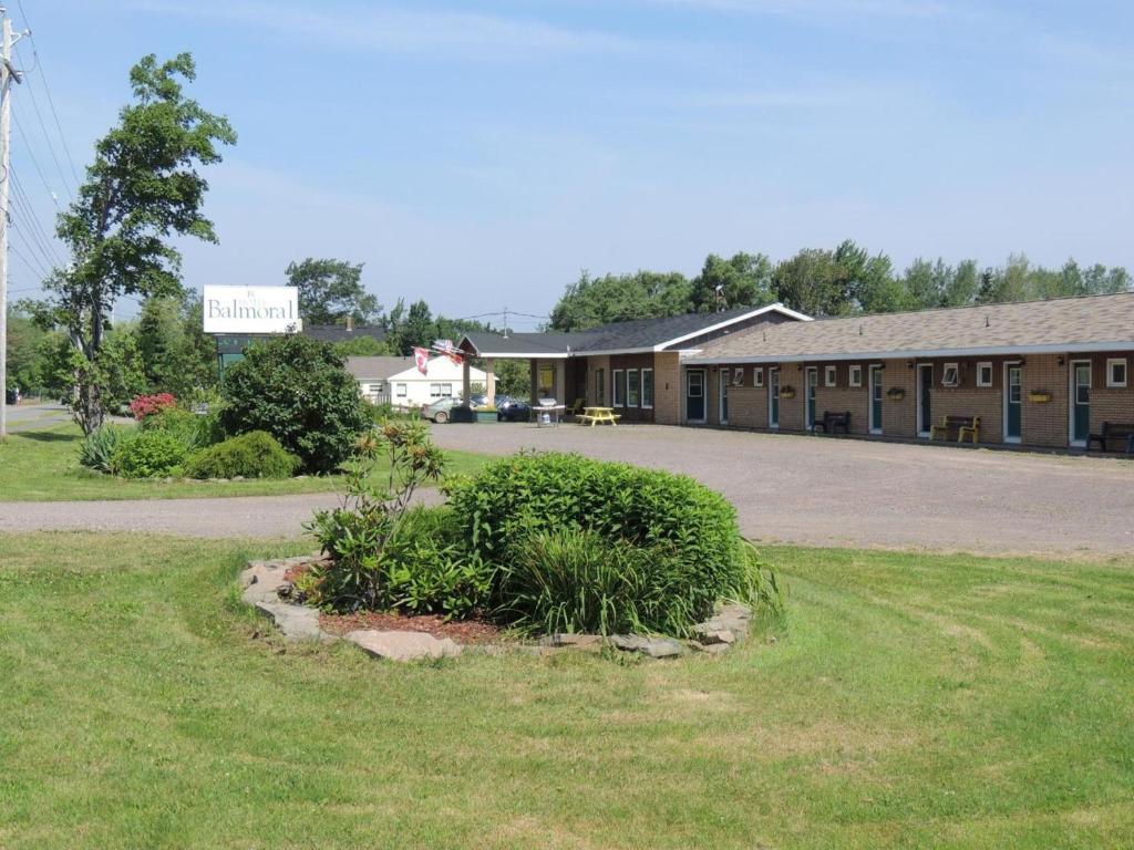 a large building with a grassy yard in front of it at Balmoral Motel in Tatamagouche