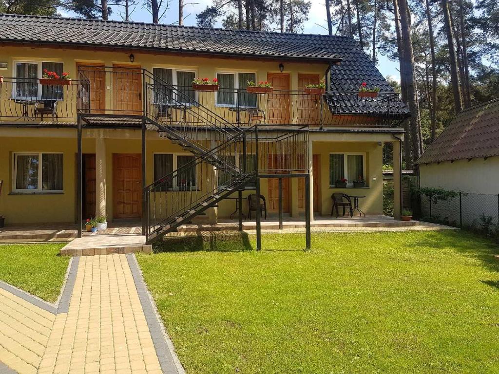 a house with a staircase in front of a yard at Dom Gościnny u Doroty in Pobierowo