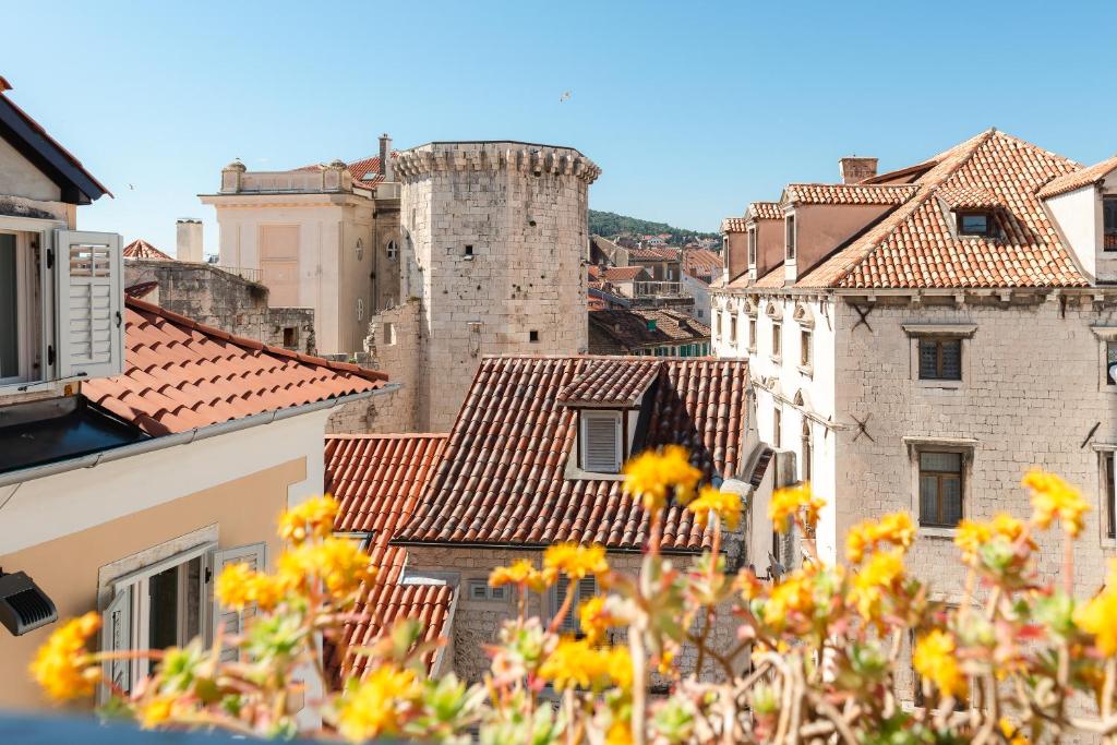 a view of a city with buildings and yellow flowers at Dosud House Studios in Split