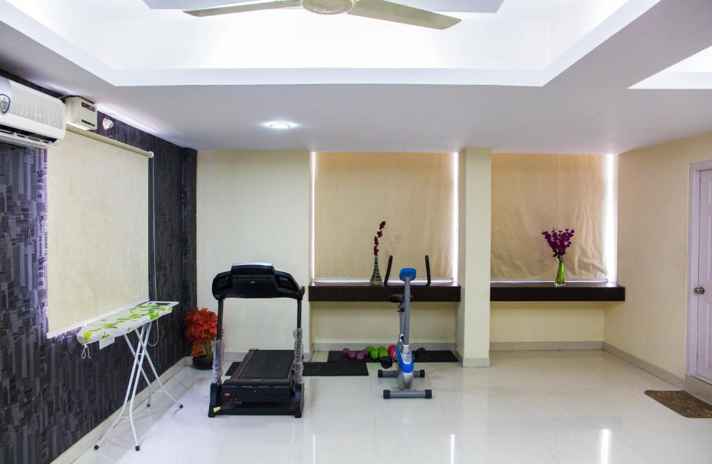 een kamer met een loopband en een fitnessruimte bij Skyla Service Apartments - Gachibowli in Hyderabad