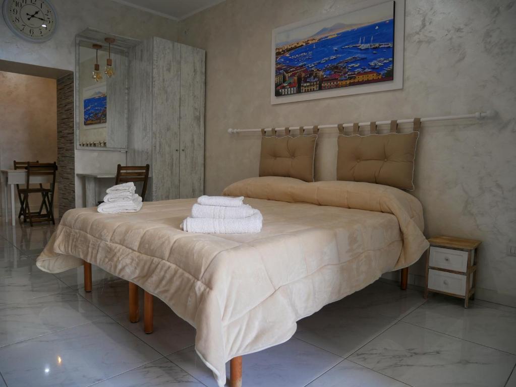 - une chambre avec un grand lit et des serviettes dans l'établissement Casetta Bebbè, à Naples