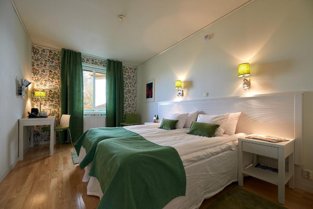 a bedroom with a large white bed with green sheets at Tofta Herrgård in Lycke
