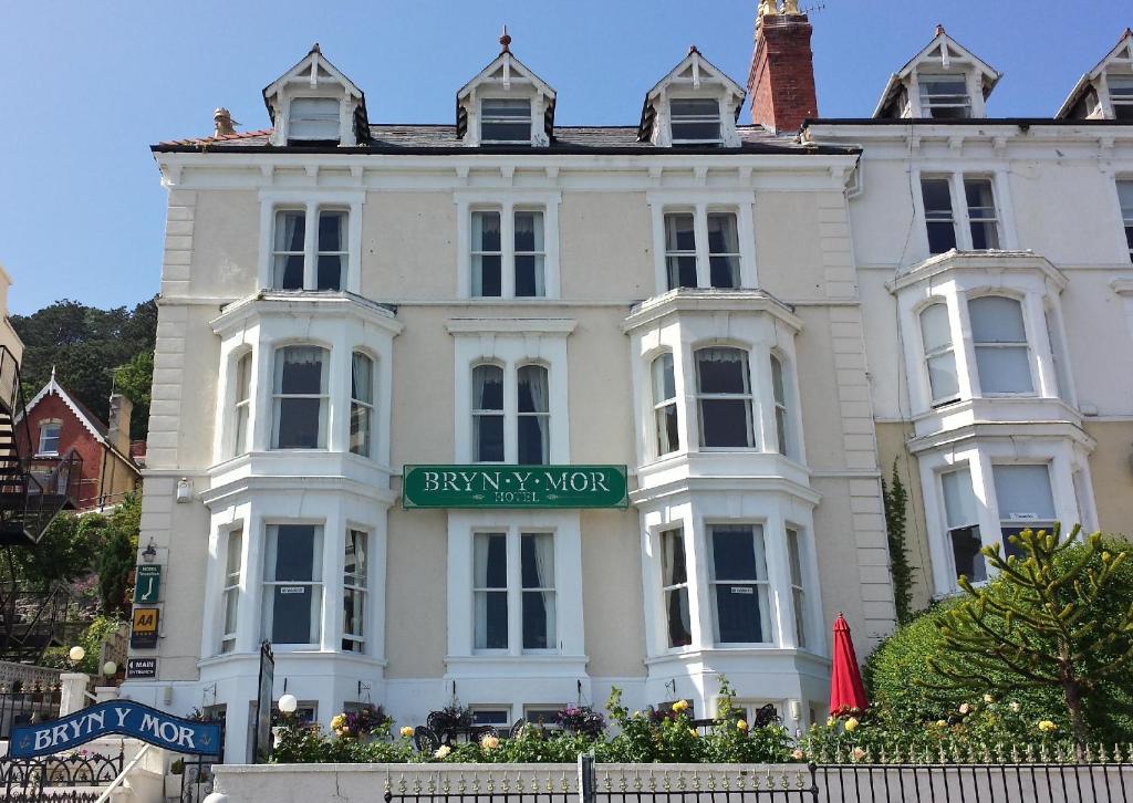 un grande edificio bianco con un cartello sopra di Bryn-Y-Mor (ADULT ONLY) a Llandudno