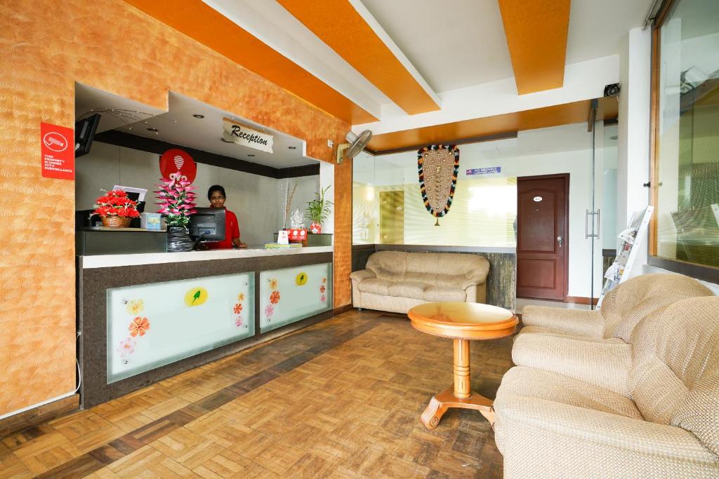 een woonkamer met 2 banken en een tafel bij MGS Residency in Kallar Vattiyar