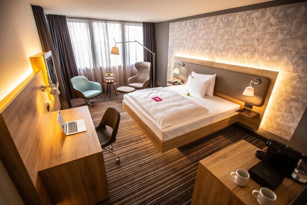 a hotel room with a bed and a desk at Leoso Hotel Leverkusen in Leverkusen