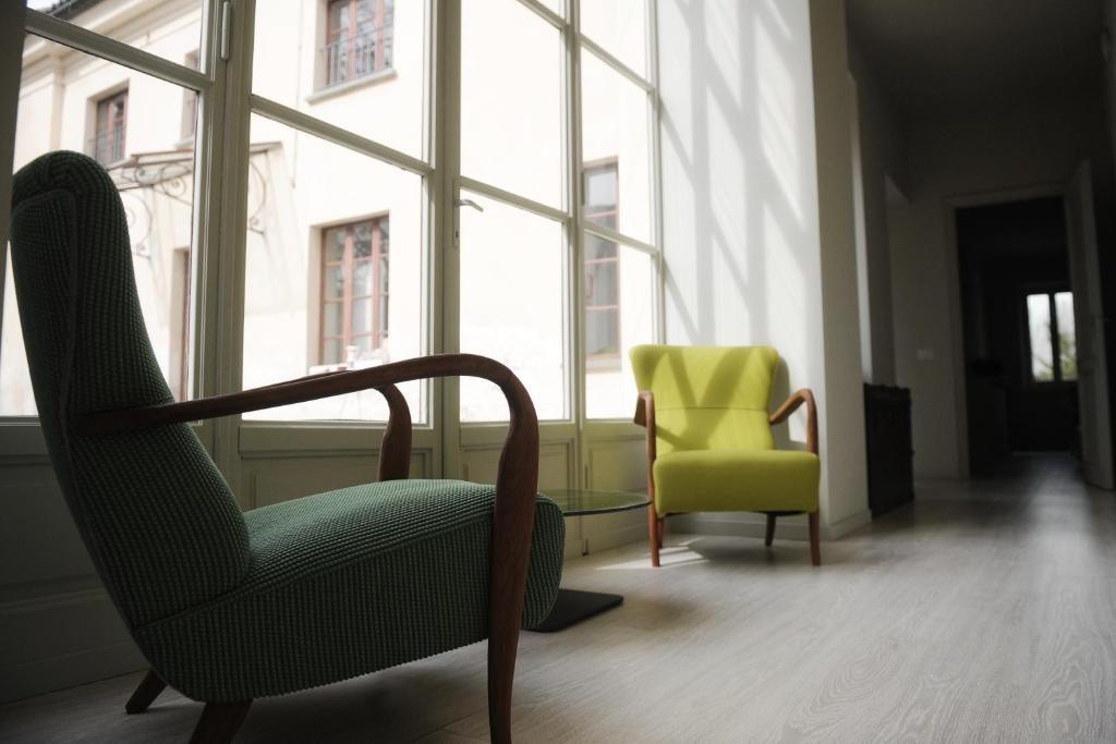 トリノにあるOasi Di Cavorettoの椅子2脚と窓が備わる客室です。