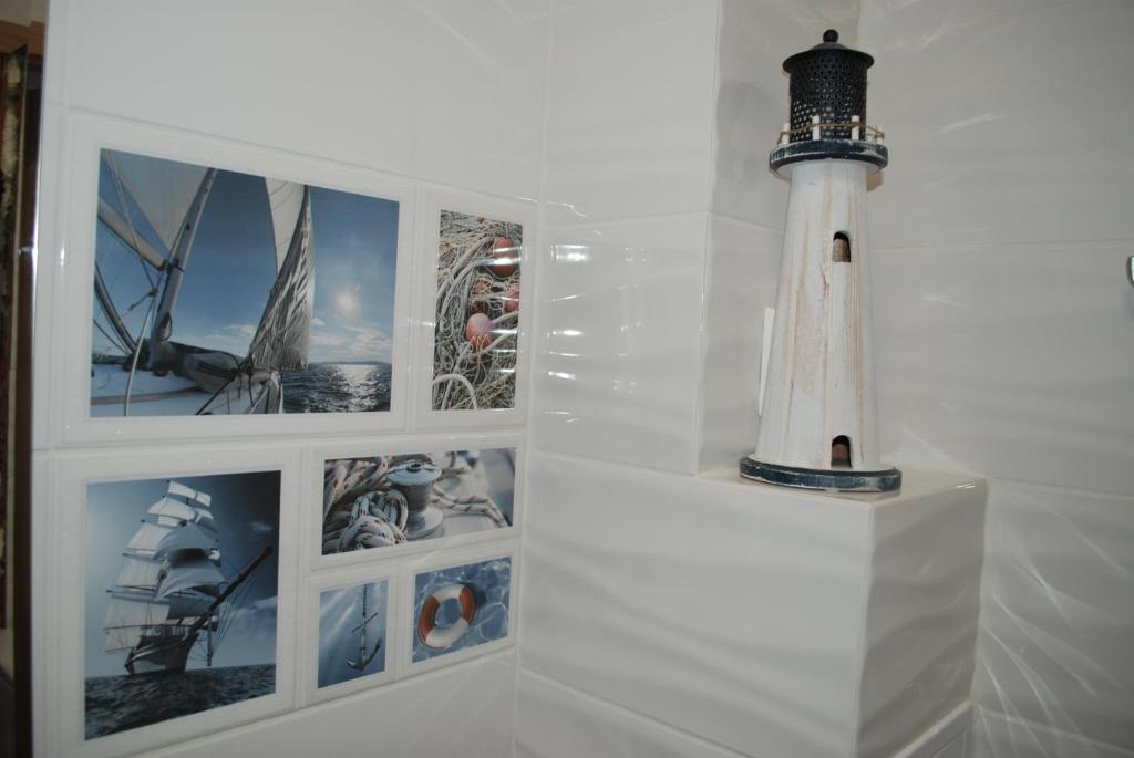 a white wall with pictures of a lighthouse on it at Apartament Morski in Hel