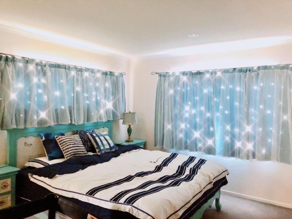 una camera con letto e tenda blu con luci di The Ocean Dream a Rotorua