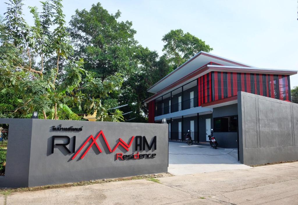 a building with a sign in front of it at Rimnamresidence in Ban Muak Lek