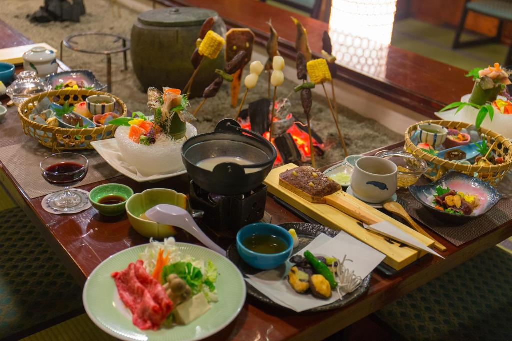 una mesa cubierta con platos de comida y palillos chinos en Honke Bankyu, en Nikko